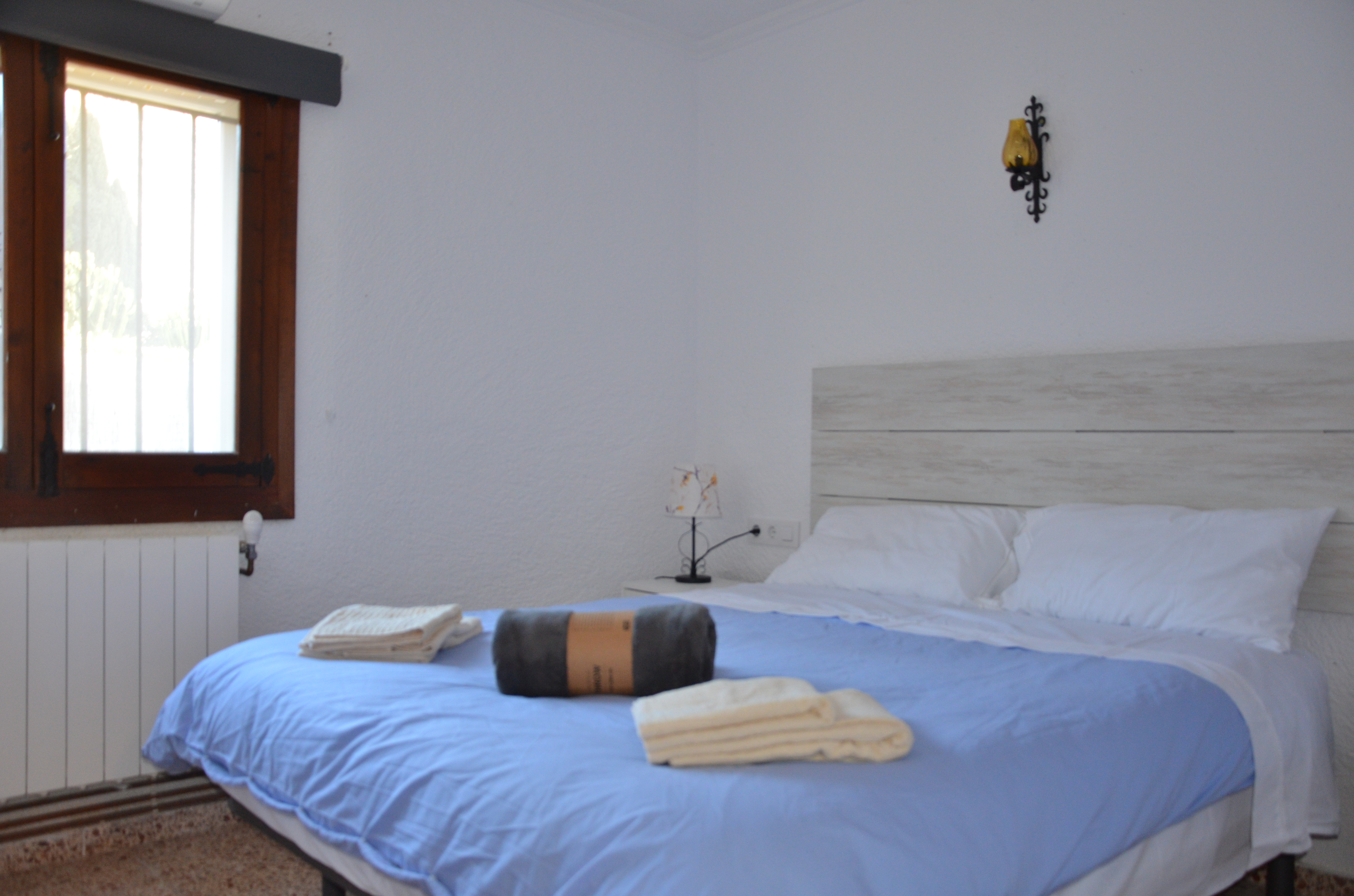 Bedroom with blue linens and wooden shutters